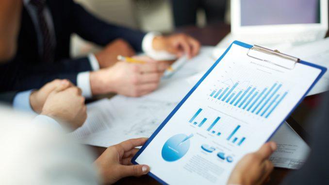 Business professionals analyzing financial charts and data in a meeting.