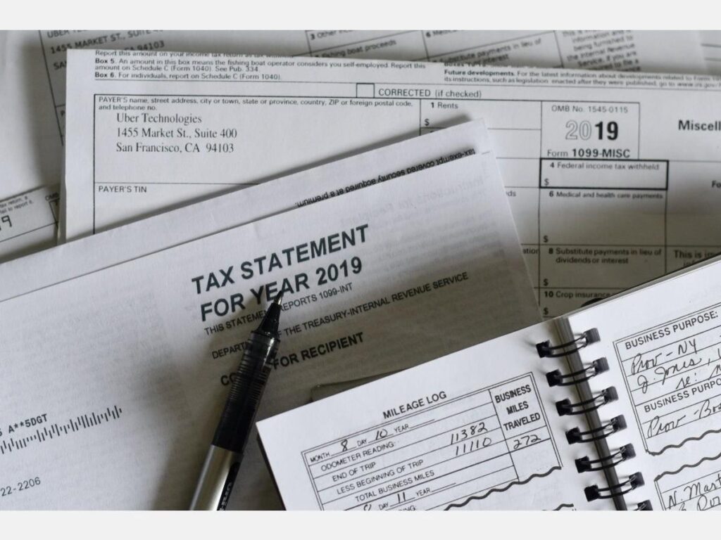 Tax documents and a pen on a desk showing 2019 tax statements.