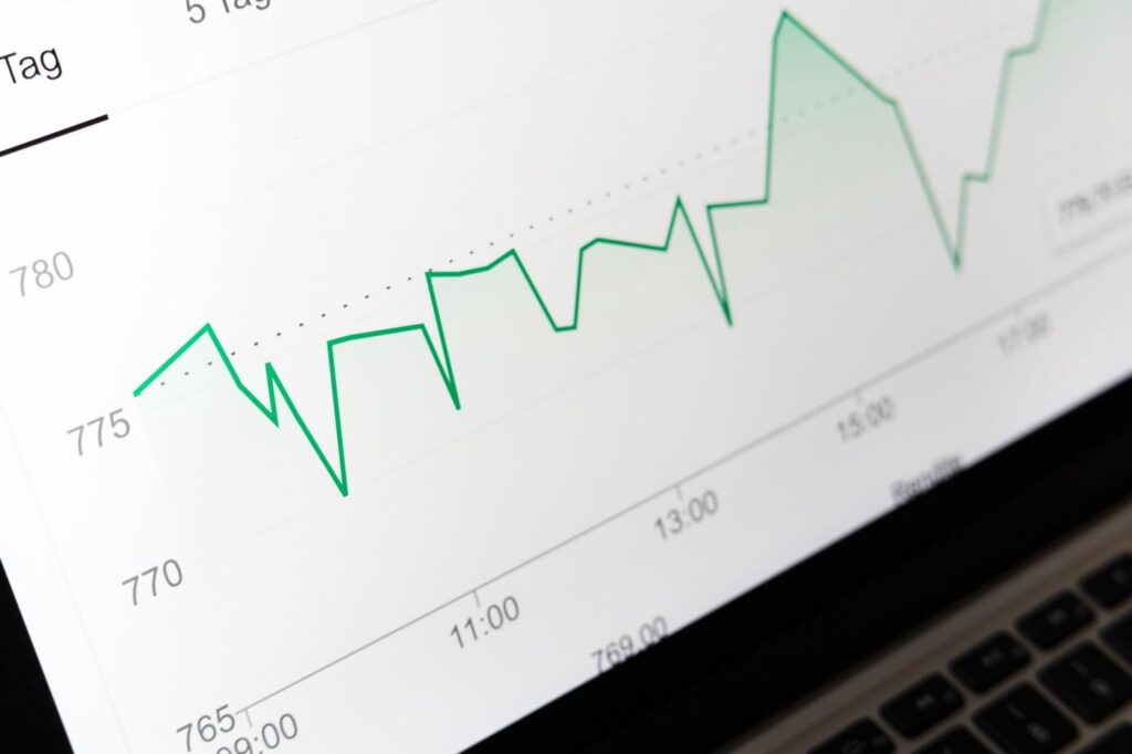 Green financial line chart on laptop screen