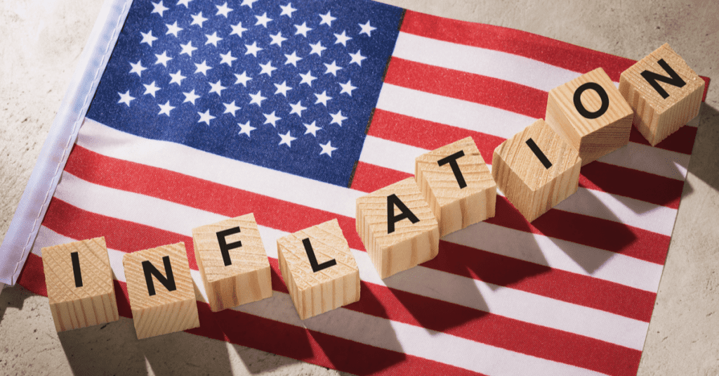 Wooden blocks spelling 'INFLATION' on the American flag.
