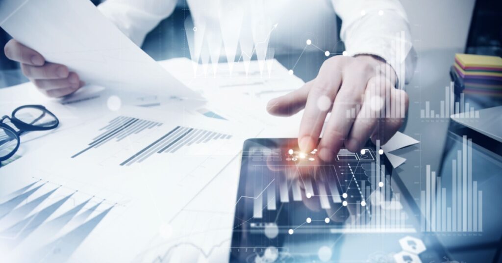 Person using a tablet with digital data overlays and graphs.