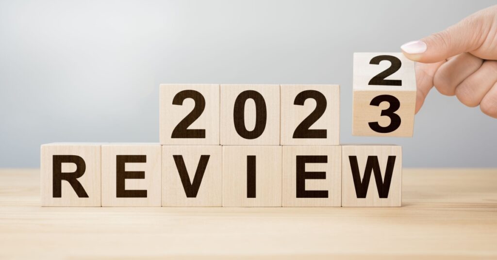 Wooden blocks spelling out '2023 REVIEW' on a table.
