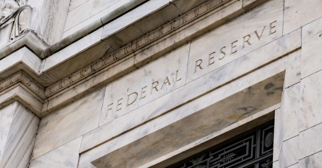 Entrance sign reading 'Federal Reserve' on a stone building.