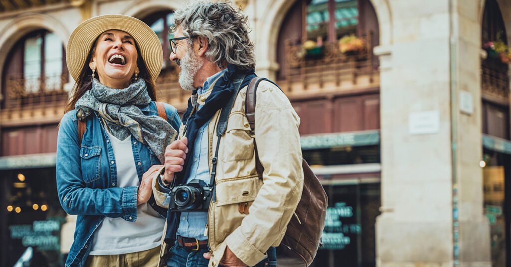 Couple laughing while sightseeing with camera