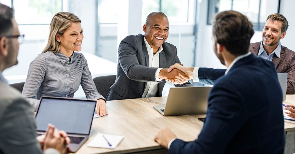 Colleagues shaking hands at business meeting