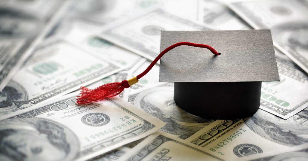 Graduation cap on scattered US dollar bills